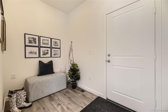 foyer entrance with baseboards, visible vents, and light wood finished floors