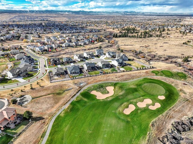 drone / aerial view with a mountain view, golf course view, and a residential view