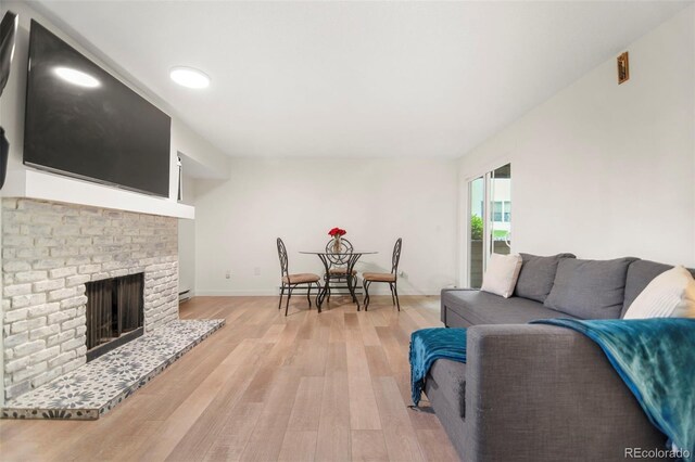 4068 S Atchison Way Unit 103, Aurora, CO 80014 - living area with light wood-style flooring, baseboards, and a fireplace