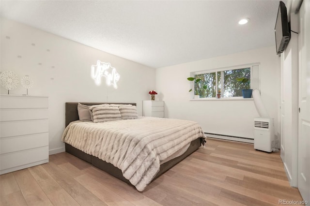 4068 S Atchison Way Unit 103, Aurora, CO 80014 - bedroom featuring a baseboard radiator, light wood-style floors, and recessed lighting