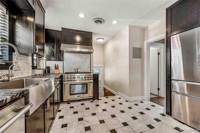 kitchen with dark stone countertops, dark brown cabinetry, appliances with stainless steel finishes, and backsplash