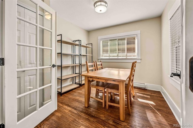 dining space with dark wood-type flooring and a baseboard heating unit