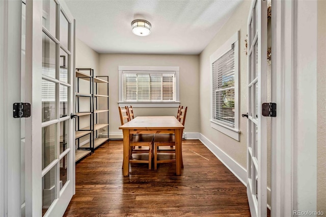 dining room with a textured ceiling, french doors, dark wood-type flooring, and baseboards