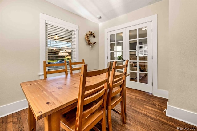 dining area featuring french doors, dark wood-style flooring, and baseboards