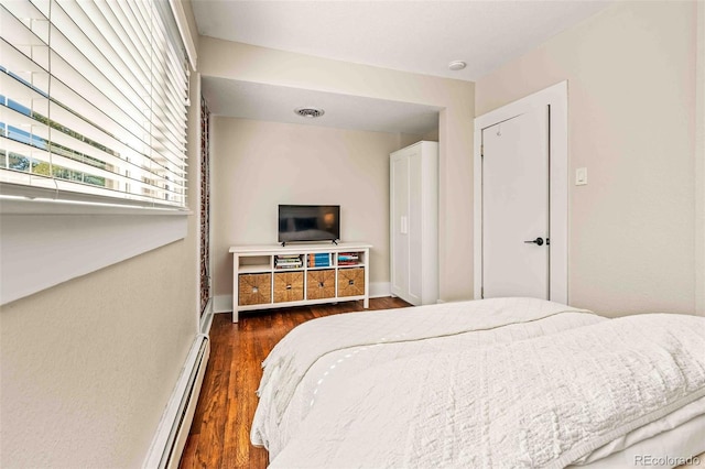 bedroom featuring dark wood-type flooring and baseboard heating