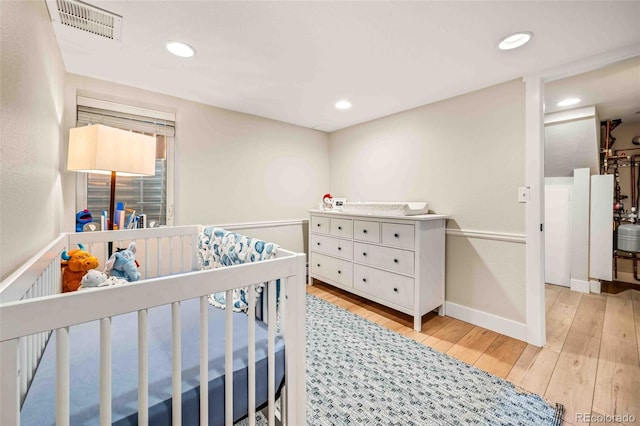 bedroom featuring light wood finished floors, visible vents, and recessed lighting