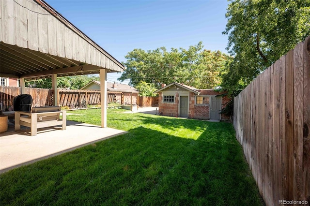 view of yard featuring an outbuilding, a patio, and a fenced backyard