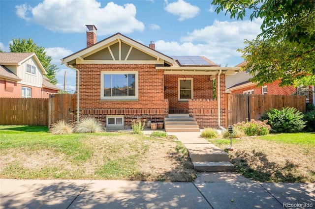 view of front of home featuring a front lawn and solar panels