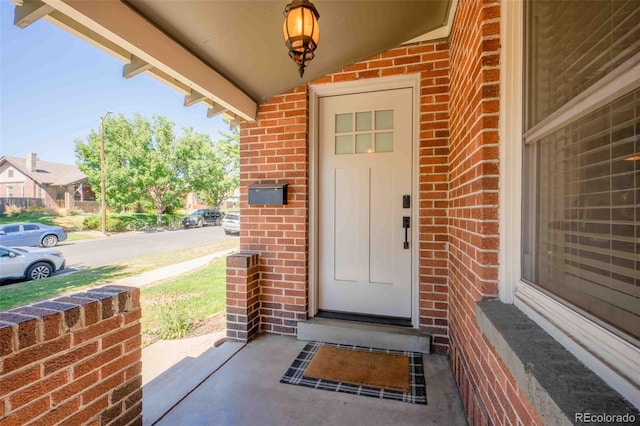 doorway to property featuring brick siding