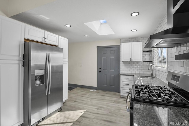 104 Stuart St, Denver, CO 80219 - kitchen with stainless steel appliances, wall chimney exhaust hood, a sink, a skylight, and white cabinetry