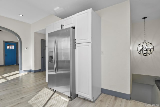 104 Stuart St, Denver, CO 80219 - kitchen with stainless steel fridge, arched walkways, baseboards, light wood finished floors, and recessed lighting