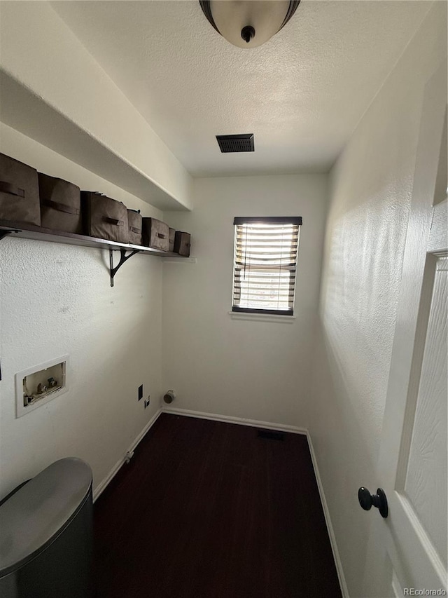 8318 Ivory Loop, Peyton, CO 80831 - laundry room featuring washer hookup, baseboards, dark wood-style flooring, and a textured ceiling