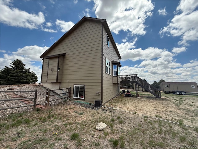 8318 Ivory Loop, Peyton, CO 80831 - view of side of property featuring fence, stairway, and a wooden deck