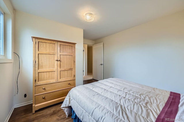 bedroom featuring baseboards and dark wood-style flooring