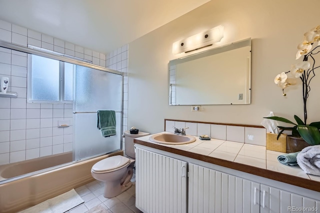 full bathroom featuring tile patterned flooring, toilet, vanity, and shower / bath combination with glass door