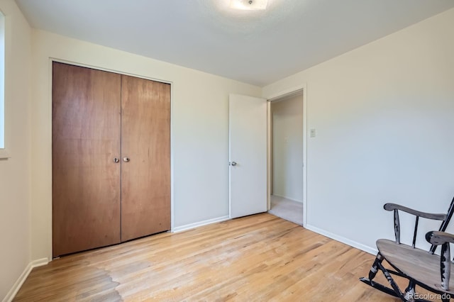 sitting room with light wood-type flooring and baseboards