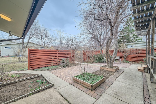 view of patio featuring a vegetable garden and a fenced backyard