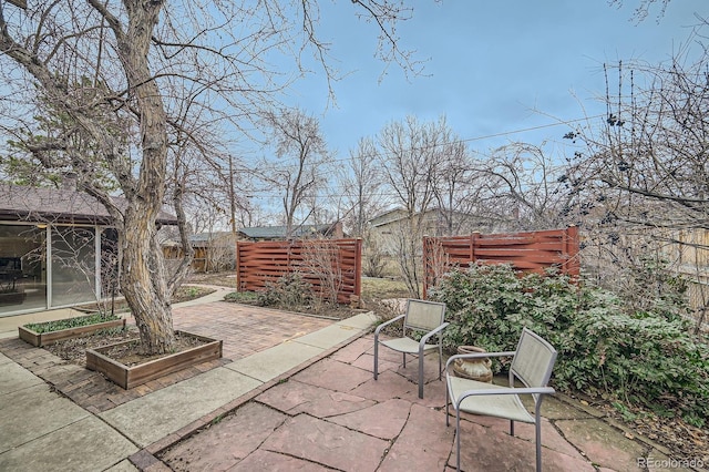 view of patio featuring a vegetable garden and fence