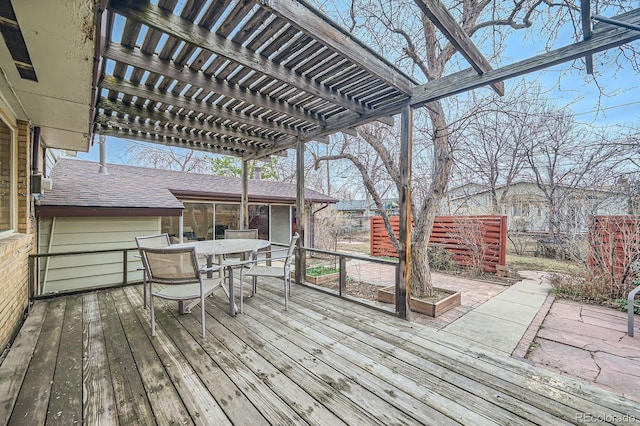 wooden terrace with outdoor dining area, fence, and a pergola