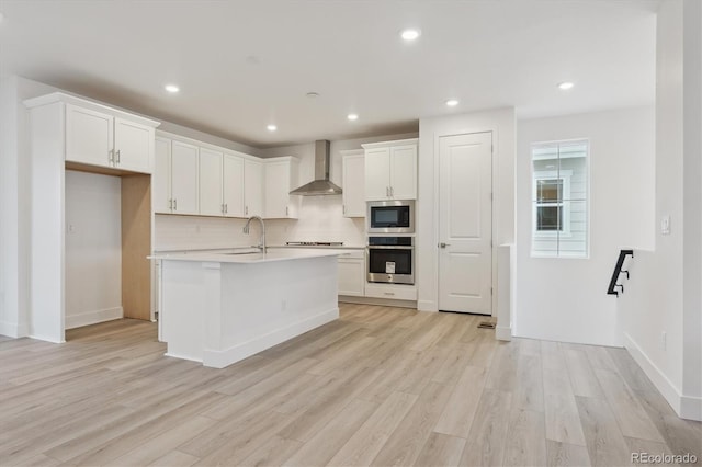 8229 Butte Creek St, Littleton, CO 80125 - kitchen with stainless steel appliances, wall chimney range hood, a sink, backsplash, and light wood finished floors