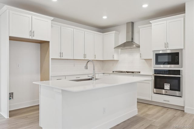 8229 Butte Creek St, Littleton, CO 80125 - kitchen featuring stainless steel appliances, wall chimney exhaust hood, a sink, light wood finished floors, and backsplash