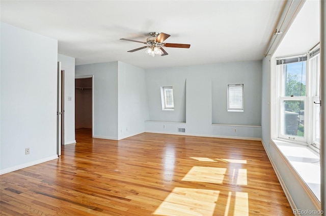 unfurnished room with light wood-style flooring, baseboards, and a ceiling fan