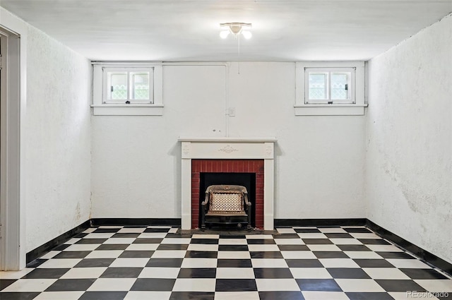 below grade area featuring tile patterned floors, plenty of natural light, a textured wall, and a brick fireplace