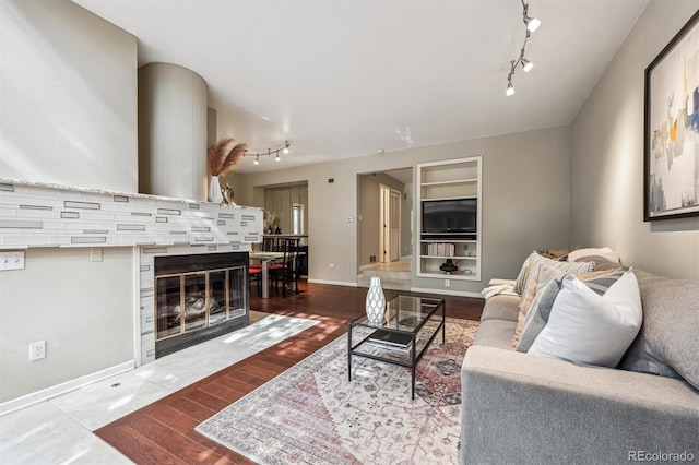 345 Harrison St, Denver, CO 80206 - living room featuring track lighting, wood finished floors, built in shelves, and baseboards