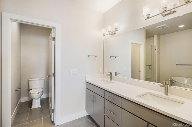 bathroom with tile flooring, a bathing tub, toilet, and dual bowl vanity