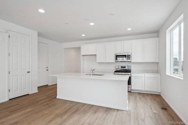 kitchen with white cabinetry, an island with sink, and appliances with stainless steel finishes