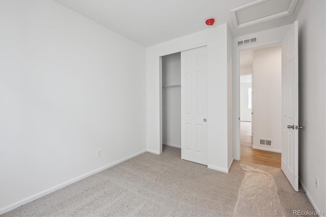 unfurnished bedroom featuring a closet and light colored carpet