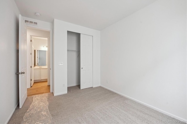 unfurnished bedroom with light carpet and a closet