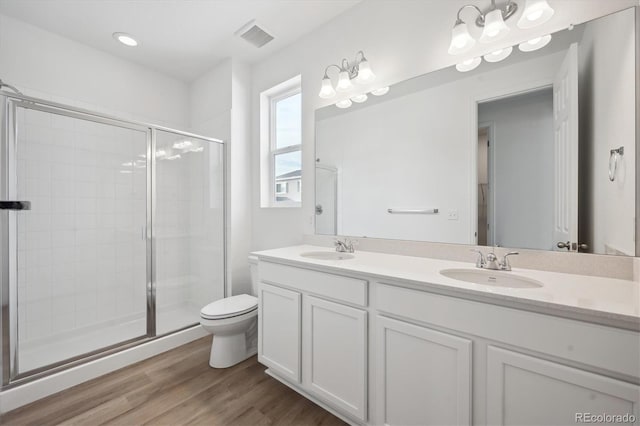 bathroom with vanity, hardwood / wood-style flooring, toilet, and walk in shower