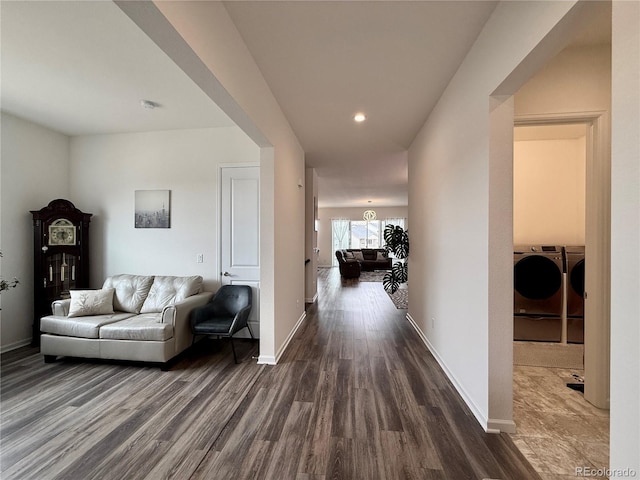 corridor featuring washer and clothes dryer, dark wood-style floors, and baseboards