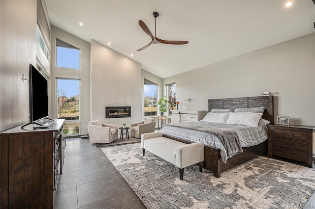 bedroom featuring ceiling fan, a large fireplace, and high vaulted ceiling