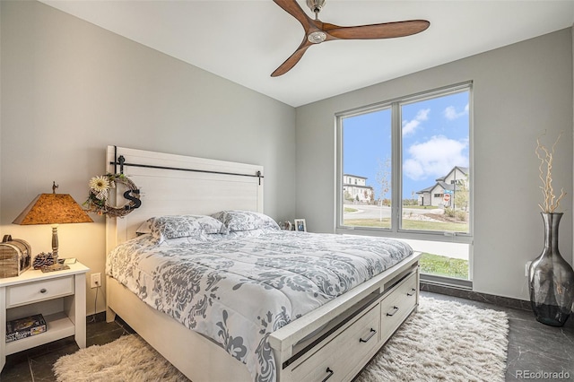 tiled bedroom featuring multiple windows and ceiling fan