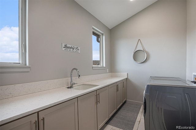 bathroom featuring tile patterned flooring, washing machine and dryer, sink, and vaulted ceiling