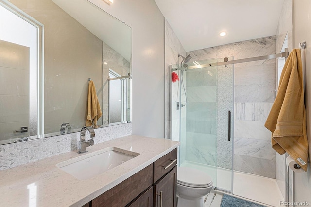 bathroom with vanity, toilet, and a shower with shower door