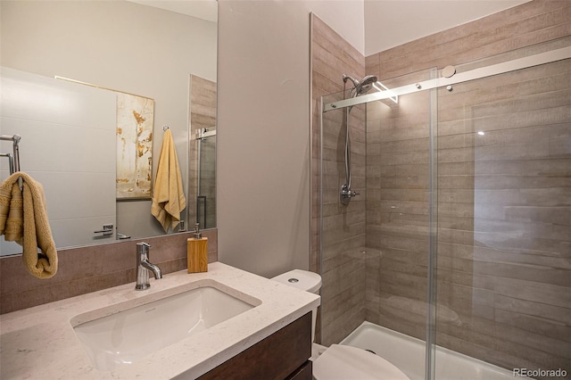 bathroom with vanity, toilet, and a shower with door