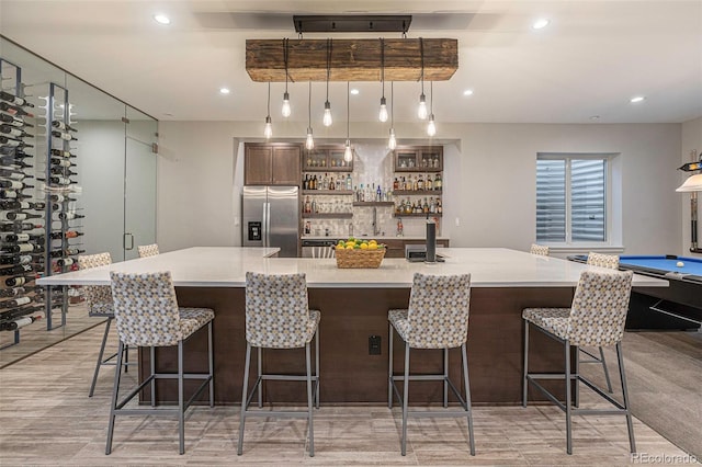 bar with light hardwood / wood-style floors, pendant lighting, stainless steel refrigerator with ice dispenser, and billiards