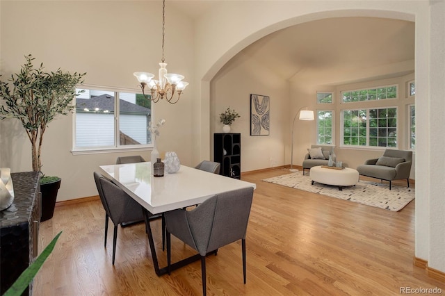 14910 Williams St, Thornton, CO 80602 - dining space featuring arched walkways, a chandelier, light wood-style flooring, and baseboards