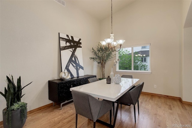 14910 Williams St, Thornton, CO 80602 - dining area featuring a chandelier, baseboards, light wood-type flooring, and high vaulted ceiling