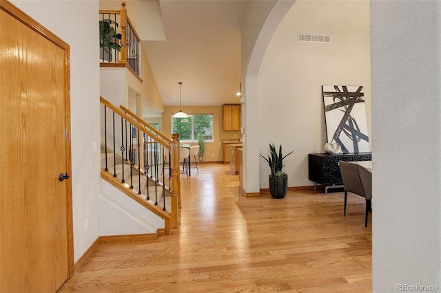 14910 Williams St, Thornton, CO 80602 - foyer featuring arched walkways, light wood finished floors, baseboards, stairway, and a high ceiling