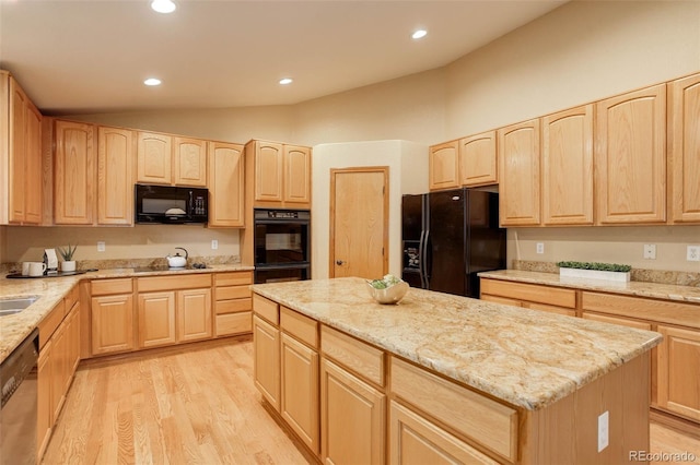 14910 Williams St, Thornton, CO 80602 - kitchen with light brown cabinetry, black appliances, lofted ceiling, light wood-style floors, and light stone countertops
