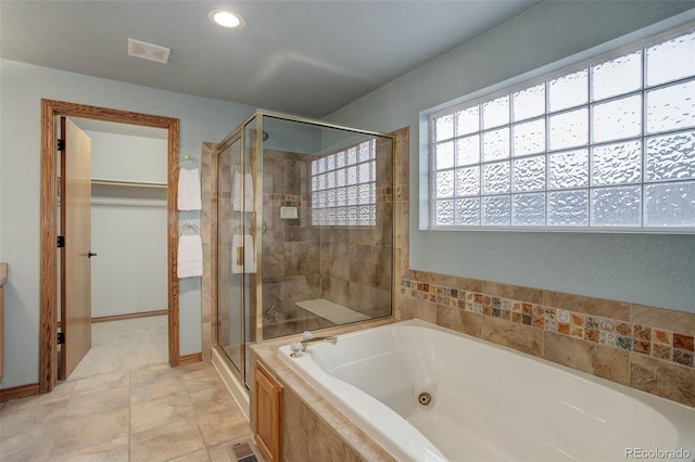 14910 Williams St, Thornton, CO 80602 - bathroom featuring a stall shower, a tub with jets, recessed lighting, baseboards, and a walk in closet