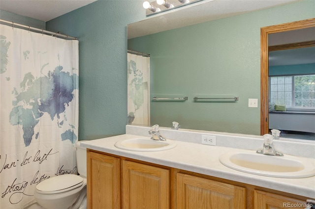 14910 Williams St, Thornton, CO 80602 - full bath featuring toilet, double vanity, a textured wall, and a shower with shower curtain
