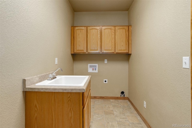 14910 Williams St, Thornton, CO 80602 - laundry area with hookup for an electric dryer, washer hookup, cabinet space, a textured wall, and baseboards