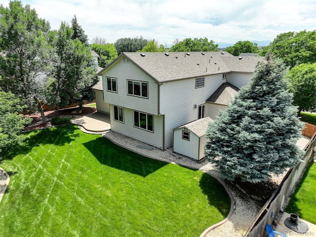 14910 Williams St, Thornton, CO 80602 - back of property with a storage unit, a patio area, and a shingled roof