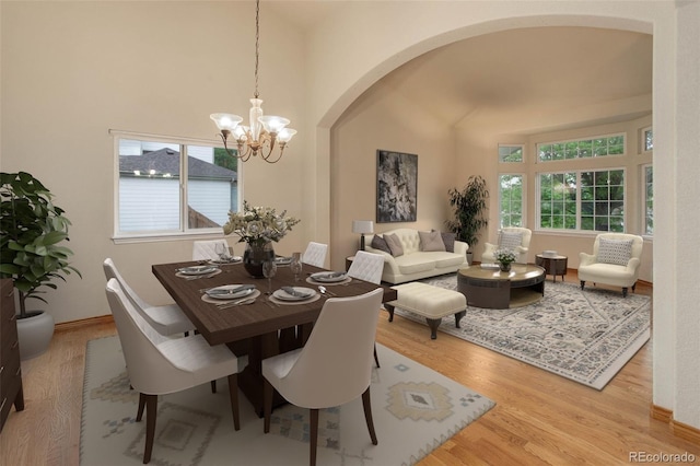 14910 Williams St, Thornton, CO 80602 - dining area featuring a chandelier, arched walkways, wood finished floors, and healthy amount of natural light