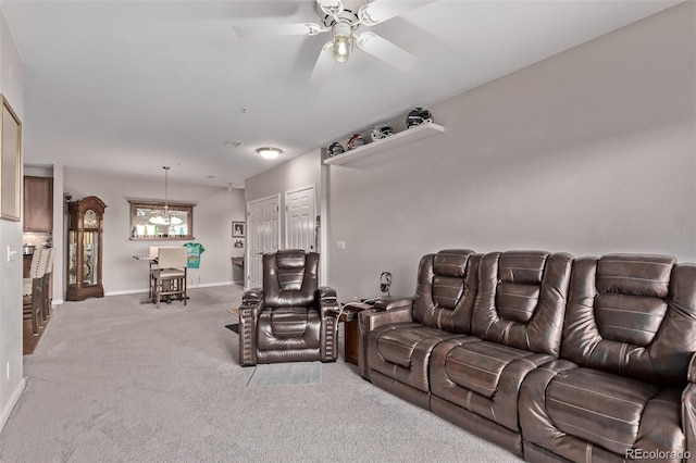 living room featuring baseboards, carpet, and ceiling fan with notable chandelier